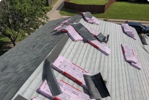 A roof that has been gutted with pink tape